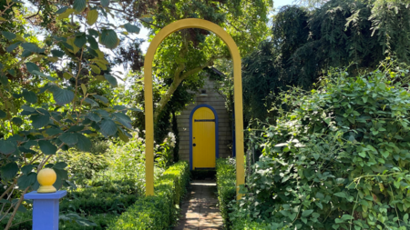Madoo garden with bright yellow archway and door